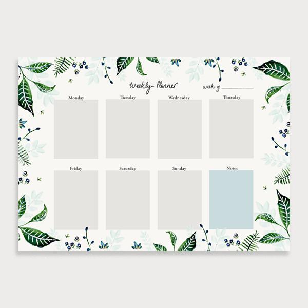 Image of illustrated weekly planner pad with a foliage leaf border. It has a title of Weekly Planner and has seperate boxes for the days of the week and a note section
