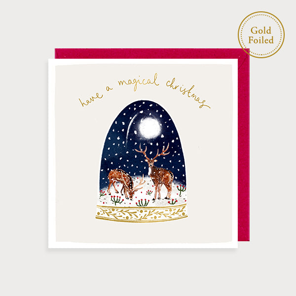Image of illustrated foiled christmas card with a snow globe with deer in it and the caption have a magical christmas